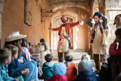 Comédiens costumés qui accueillent les enfants au château de Castelnau.