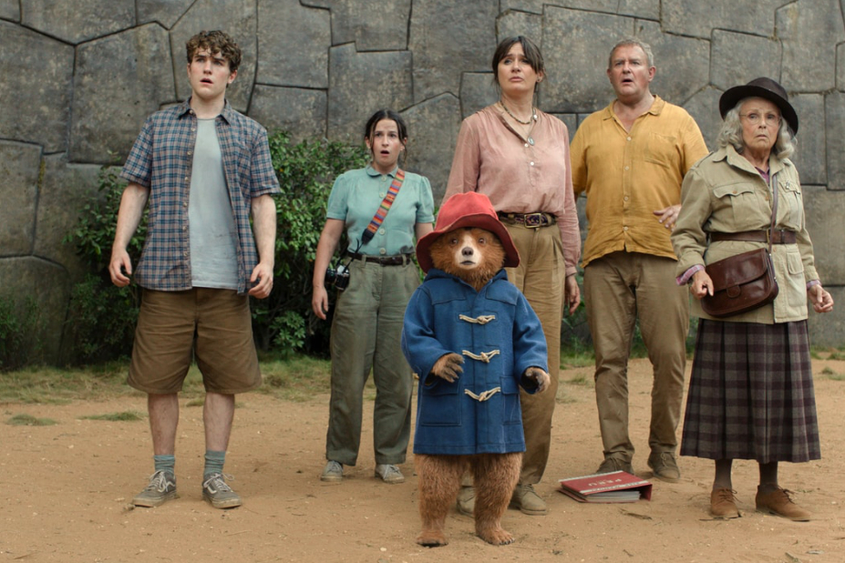 La famille adoptive de Paddington, et Paddington devant eux. Tous regardent devant eux d'un air étonné. On ignore ce qu'ils voient. 