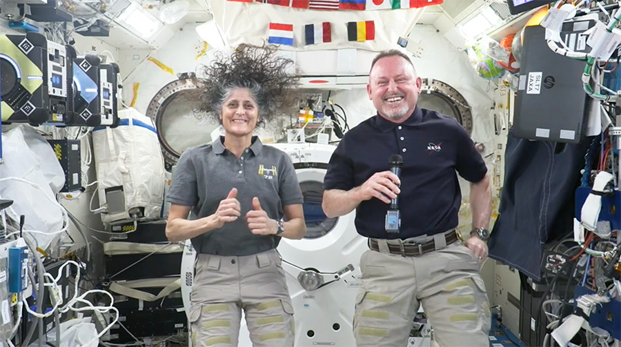 Photo montrant les 2 astronautes américains à bord de l'ISS. Tous les deux mots sont très souriants.